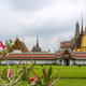 A cleaner sweeps a field in front of the Grand Palace in Bangkok.